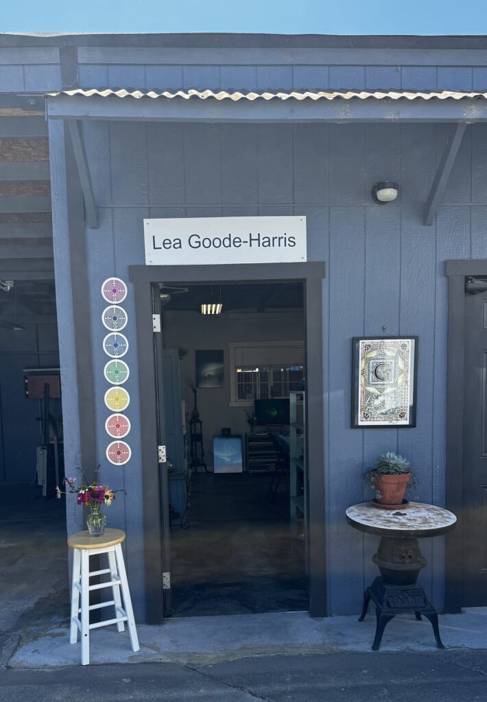 A blue building with a white stool and some flowers