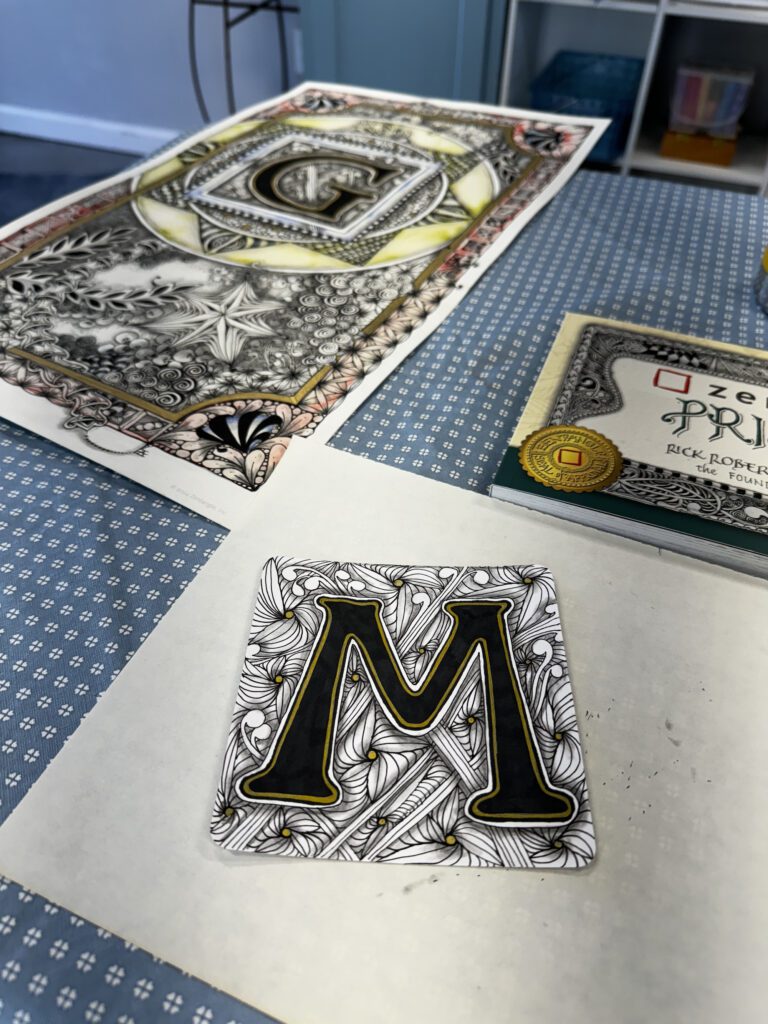 A close up of the letter m on top of a book.