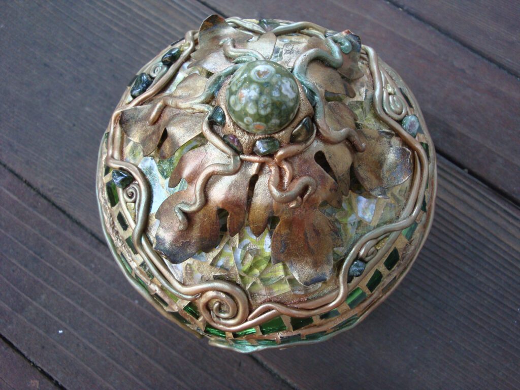 A decorative bowl with a green and gold design.