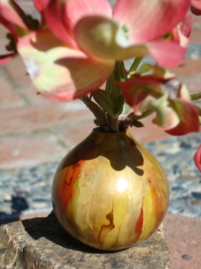 A vase with flowers in it on the ground.