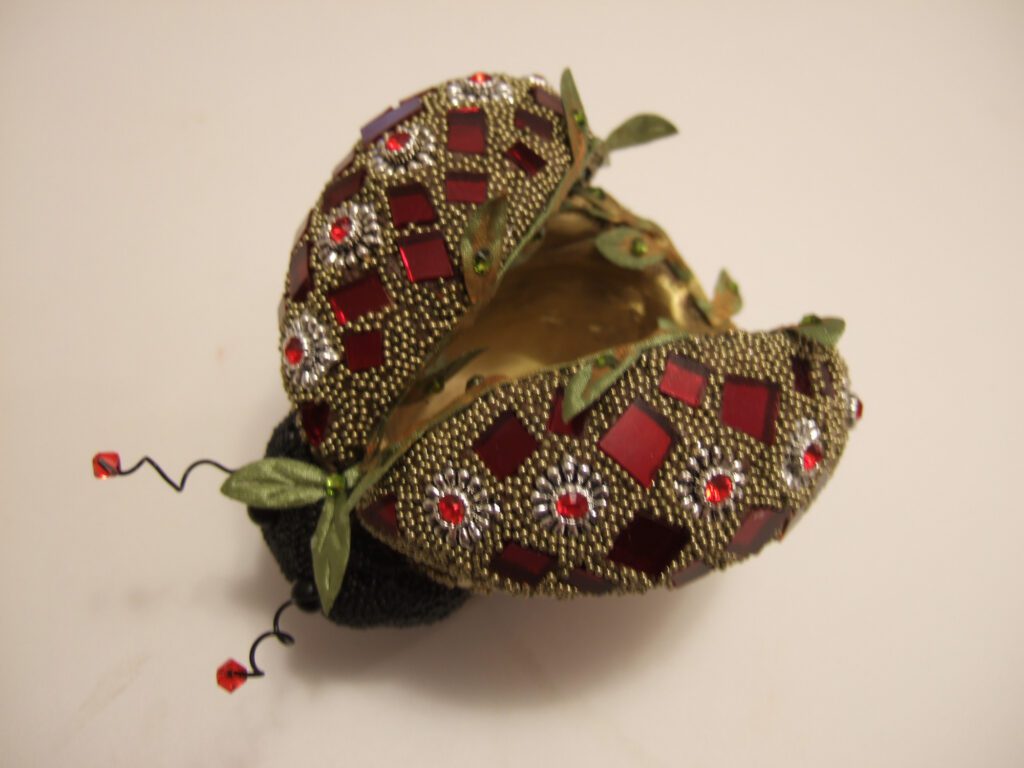 A close up of an open egg with red and gold decoration