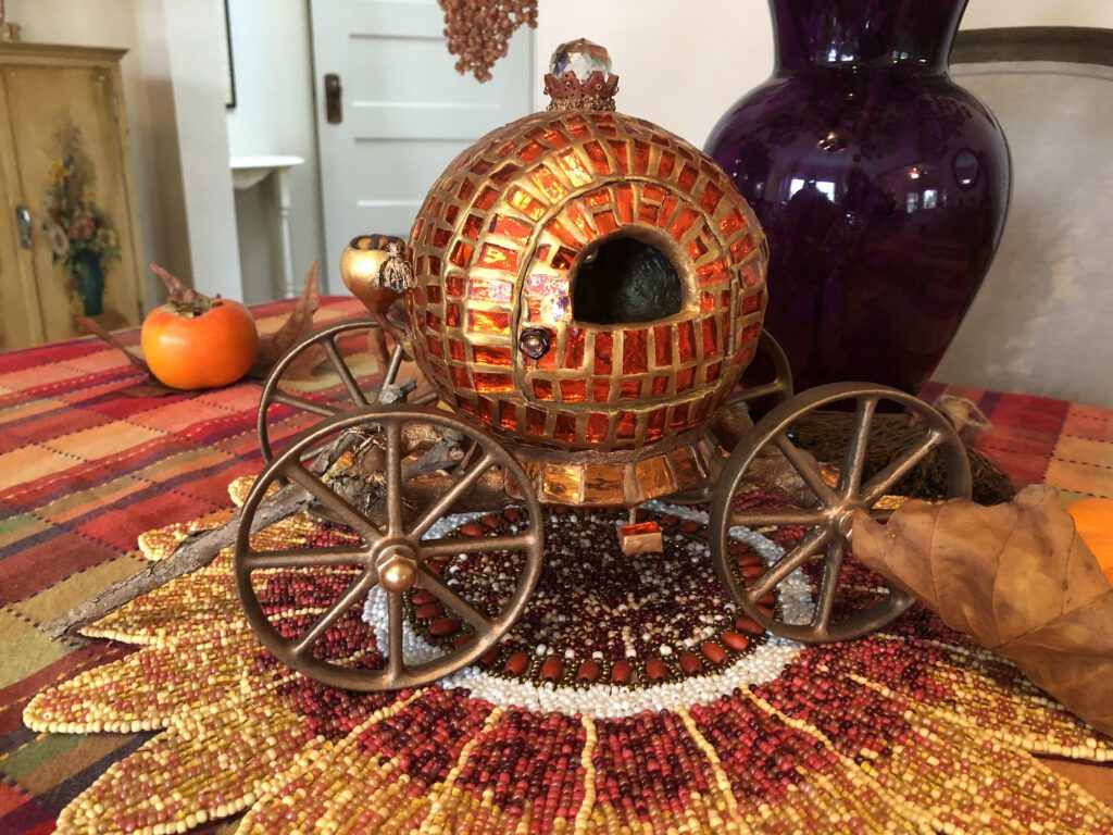 A pumpkin carriage on top of a table.